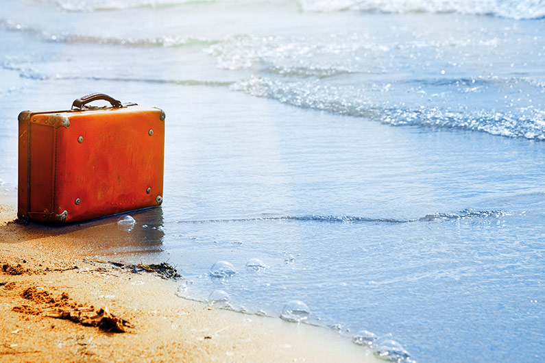 Imagen de una maleta en una playa.