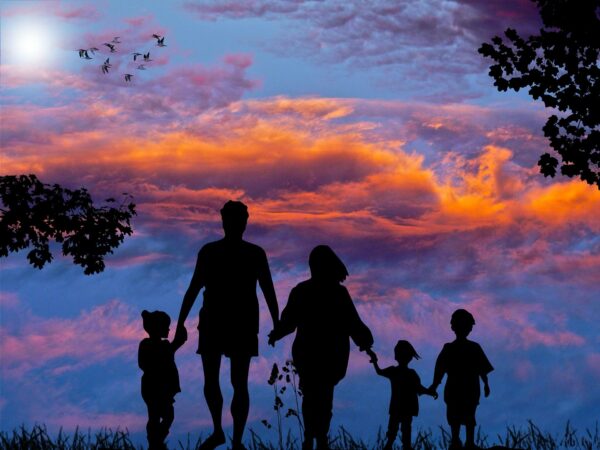 Familia de cinco miembros paseando por el campo contemplando un anochecer